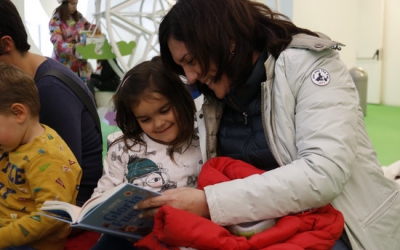 Una mare amb la seva filla llegint un conte | ACN