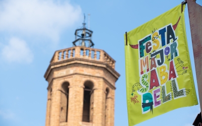Un cartell de Festa Major, amb el campanar de Sant Fèlix de fons/ Roger Benet