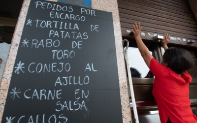 Imatge d'una restauradora obrint la persiana del seu establiment | Roger Benet