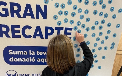 Una voluntària, amb el cartell de la campanya de l'any passat/ Banc dels Aliments