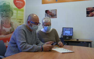 Una de les persones de suport explicant com fer el tràmit a una usuària del complex Sant Oleguer | Cedida