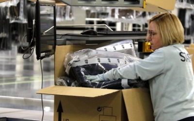 Una operària plegant roba/ ACN