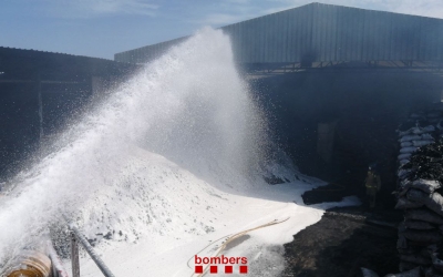 Tasques d'extinció al magatzem amb el foc ja estabilitzat/ Bombers