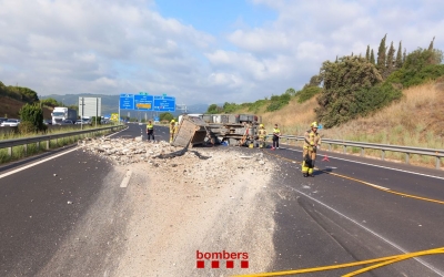 Els Bombers netegen l'AP7 després que un camió amb runa hagi bolcat